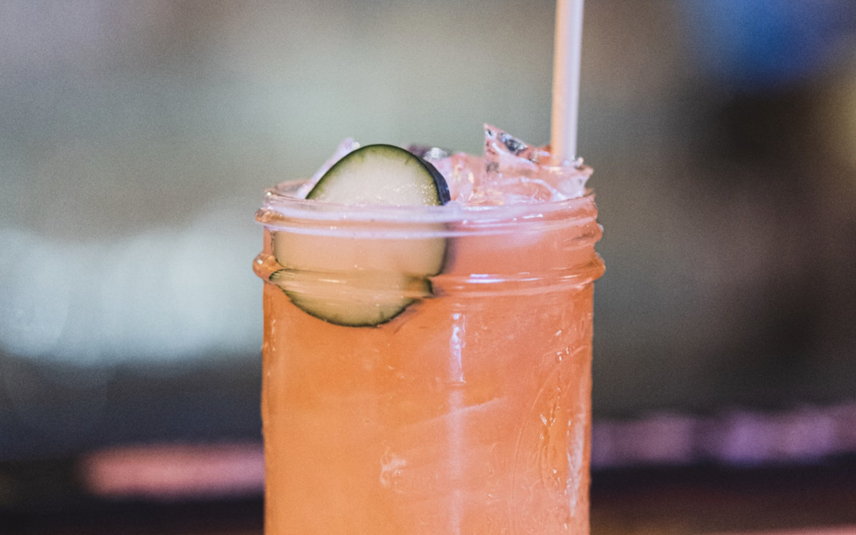 A gin and grapefruit cocktail  with a cucumber garnish.